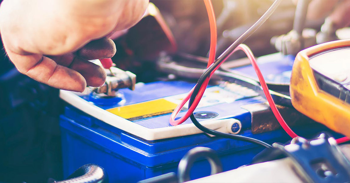 Mechanic working on a car battery.