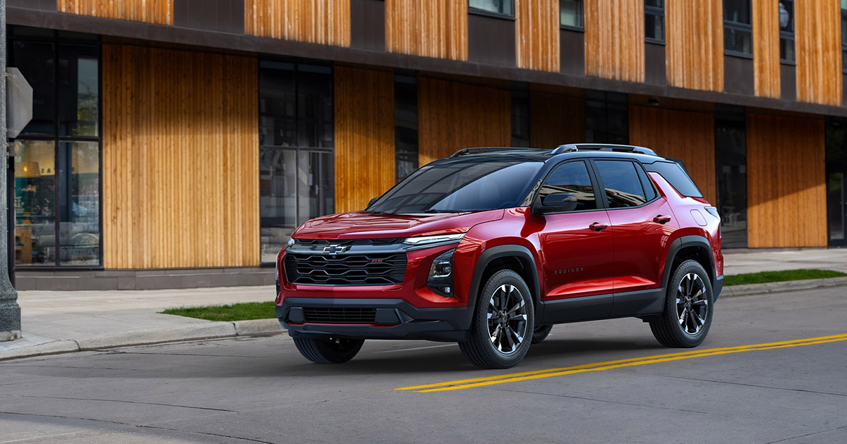 2025 Chevrolet Equinox RS SUV in red parked on city street, featuring modern design and sporty styling, available near South Bay Ford in Los Angeles, CA.
