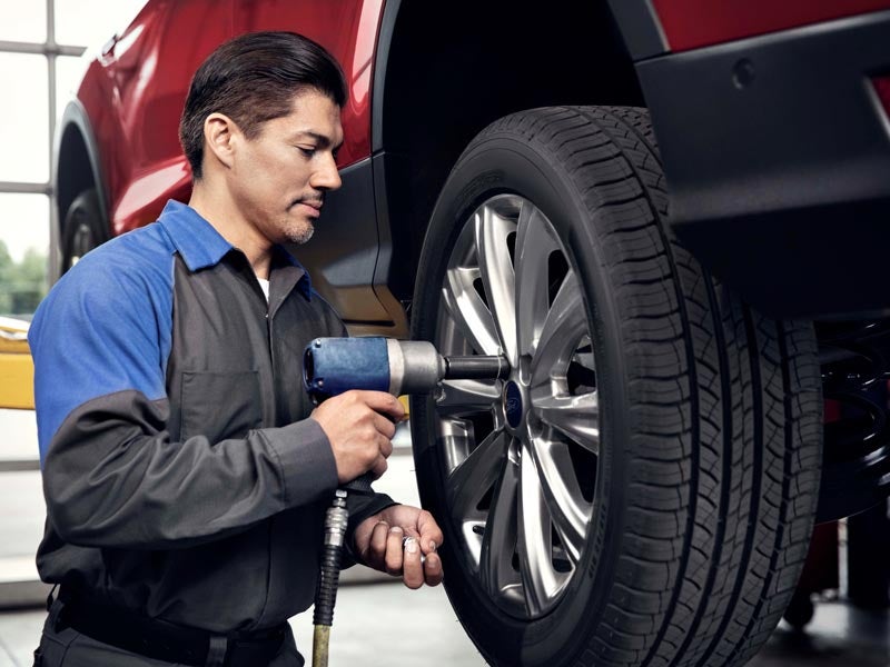 Technician installing car tire